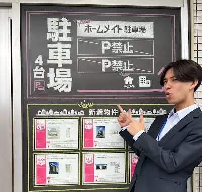 エステートプラスの店舗前で案内するスタッフ